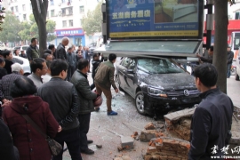 十堰新手司机停车玩“穿越” 路边阅报栏惨被撞